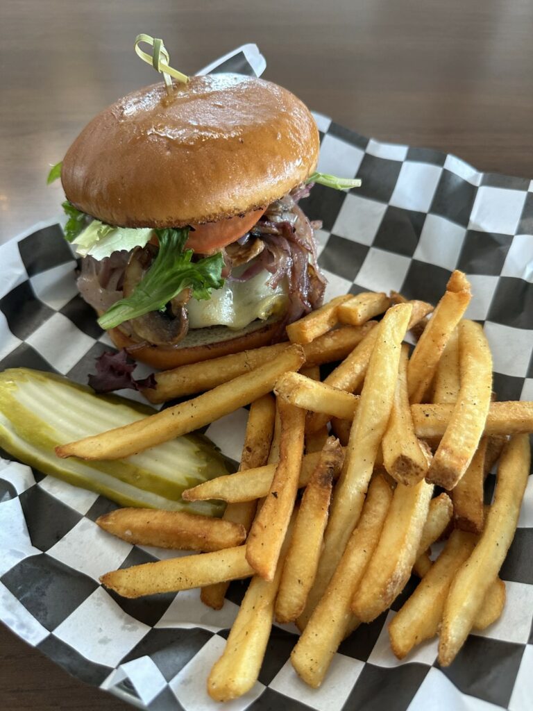 Gourmet burger and fries on checkered paper.