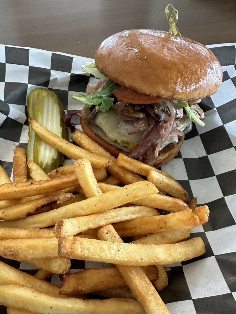 Gourmet burger and fries on checkered tablecloth.