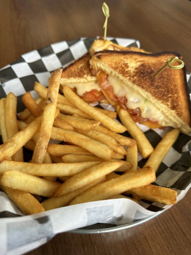 Grilled cheese sandwich with fries in basket.