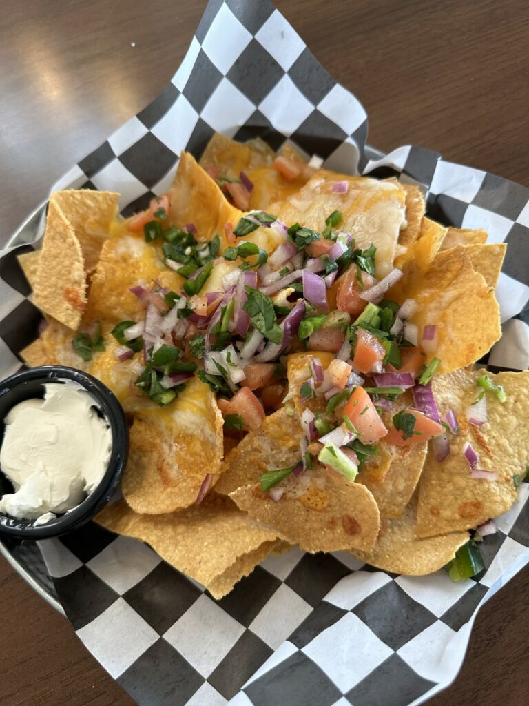 Loaded cheese nachos with fresh toppings and sour cream.